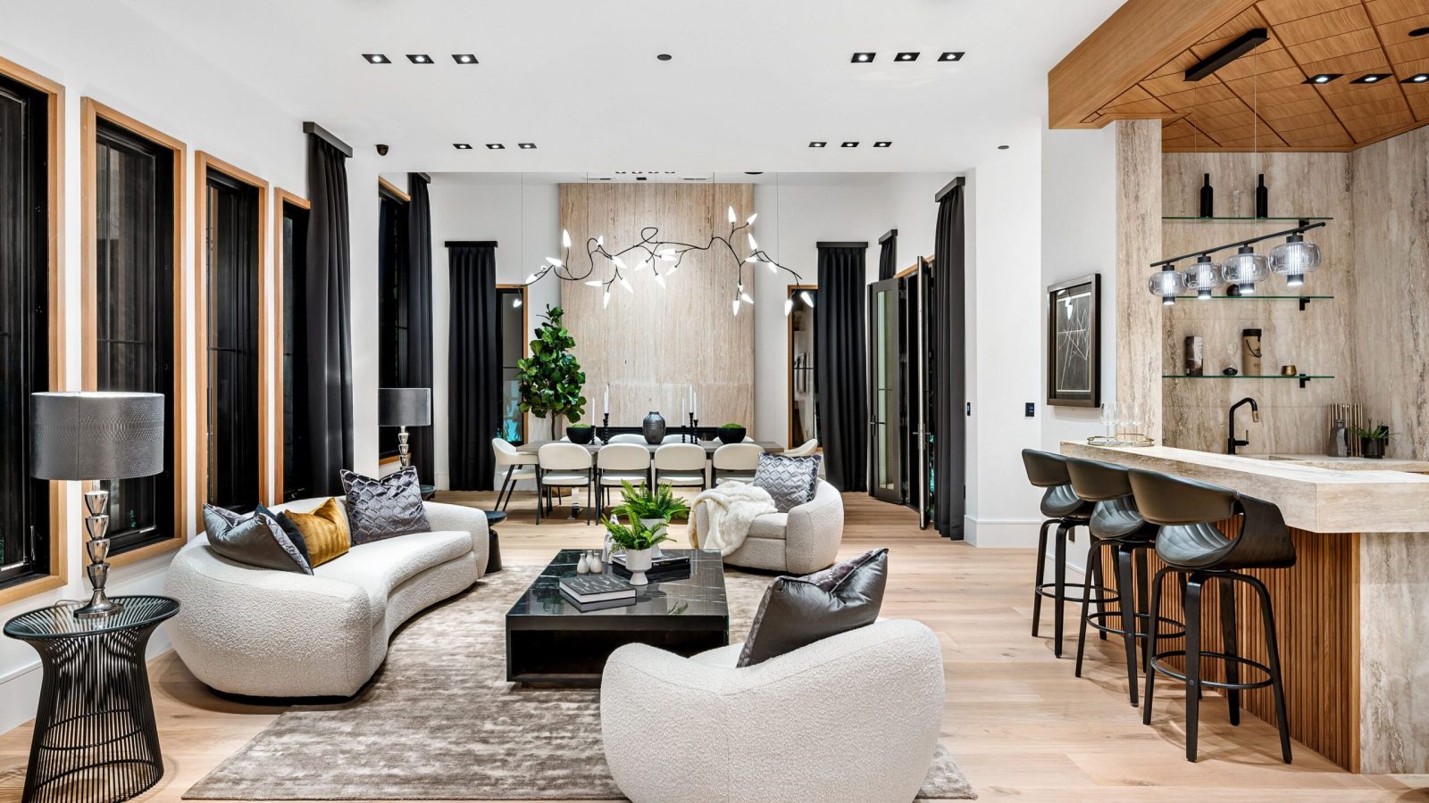 Modern luxury living room with contemporary furniture, bar area, and stylish decor, featuring neutral tones and natural light.